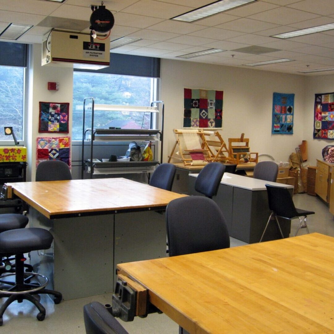 A bright classroom with tables, chairs, and colorful artwork on the walls.